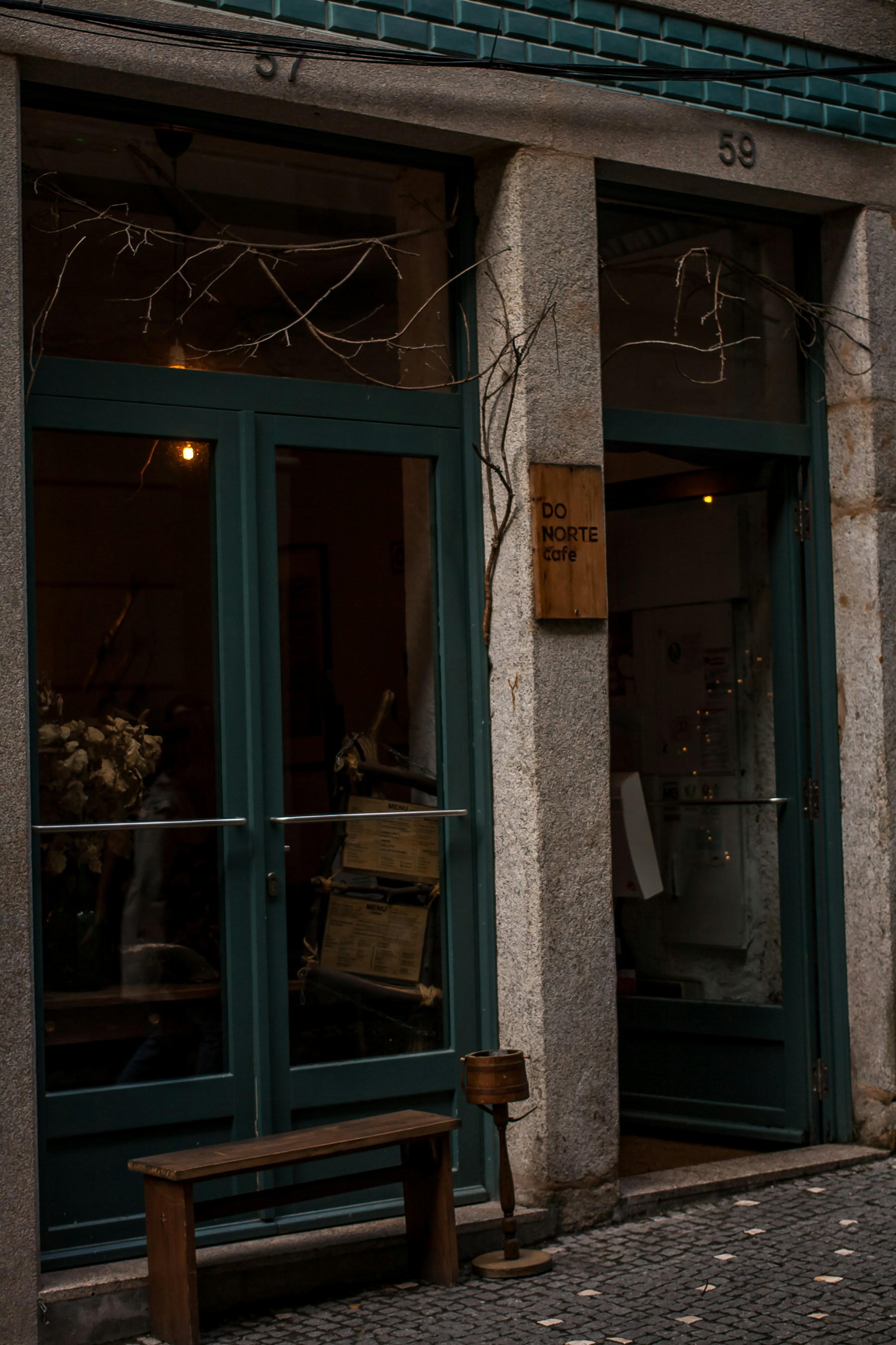Tables outside a small café on a quiet Porto street